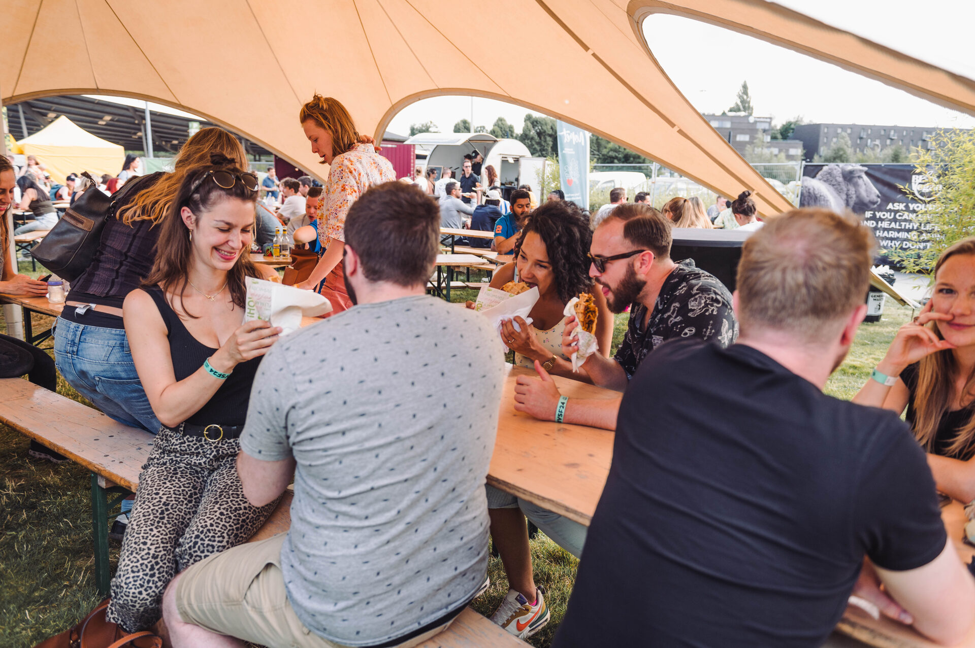 Vegan Summer Fest — crowds eating under the marquee beside a BE Vegan banner